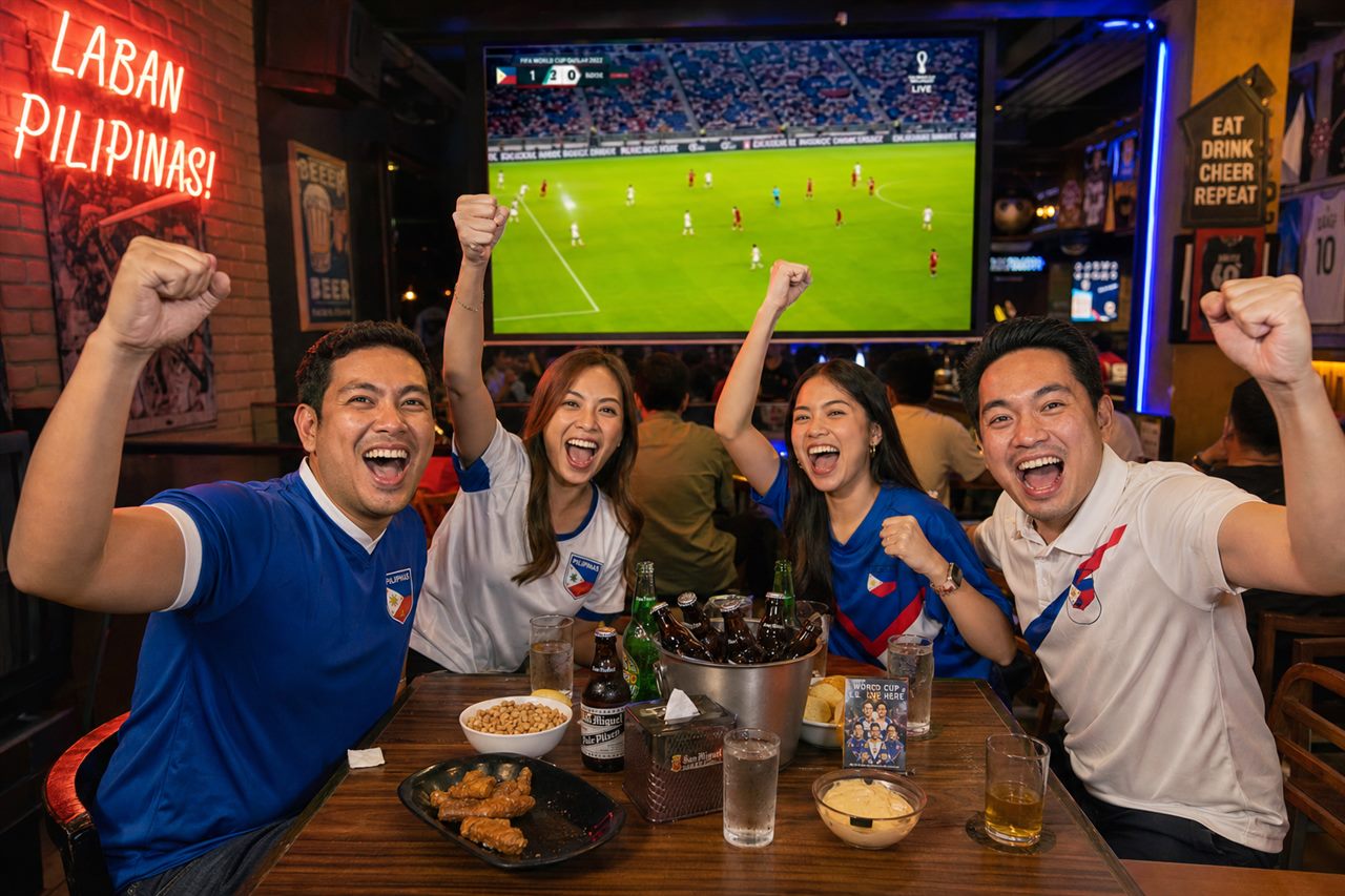 Group of Filipino friends cheering at a sports bar watching World Cup 2026 football